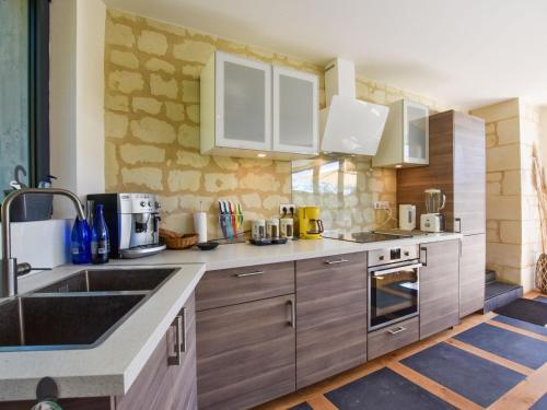 a kitchen with wooden cabinets and a sink at Holiday home near Thizay with private pool in Thizay