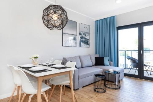salon z kanapą i stołem w obiekcie Apartamenty Gardenia Seaside by Noclegi Renters w Dziwnowie