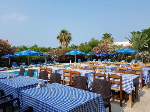 a group of tables and chairs with blue umbrellas at Paradise in Kérynia