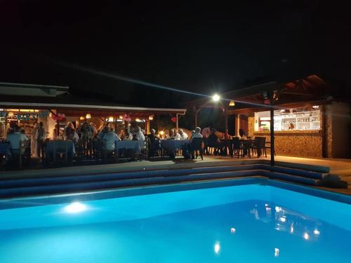a pool in front of a restaurant at night at Paradise in Kérynia