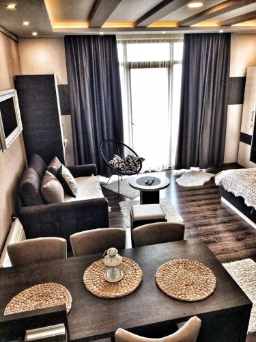 a living room with a couch and a table and chairs at Silver Mountain Milmari in Kopaonik