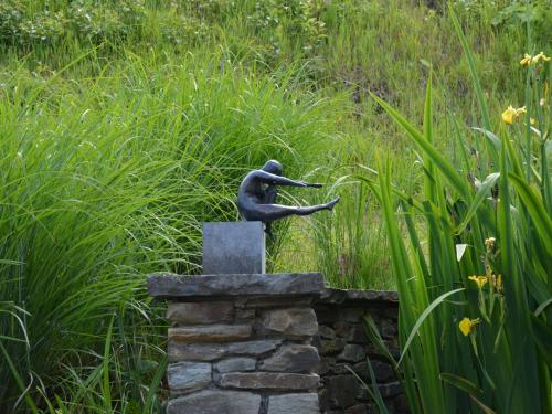 a statue of a person standing on top of a stone wall at Holiday Home in Bièvre with Terrace in Bièvre