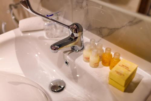 a bathroom sink with a faucet and bottles on it at HOTEL FRANCA ULCINJ in Ulcinj