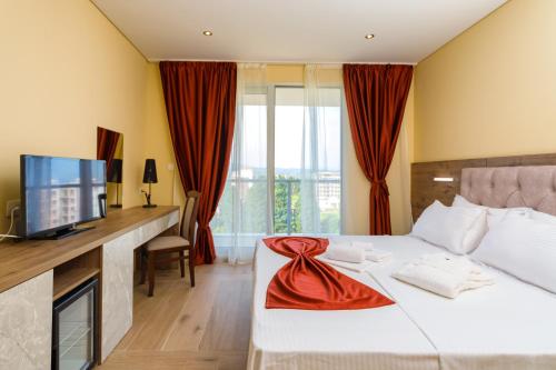 a hotel room with a bed and a desk with a television at HOTEL FRANCA ULCINJ in Ulcinj