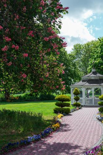 a garden with a gazebo and a brick path at Thornton Hall Hotel & Spa in Heswall