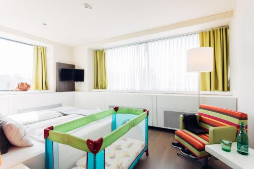 a hotel room with a bed and a chair at harry's home Wien hotel & apartments in Vienna