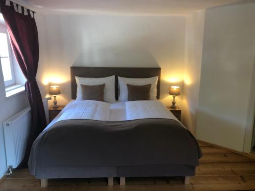 a bedroom with a large bed with two lamps at Fenix Hall Boutique Hotel Hallstatt in Hallstatt