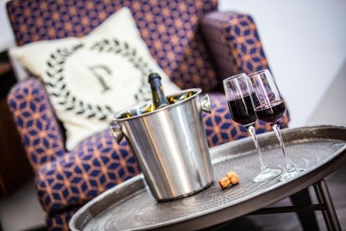 a table with two glasses of wine on a table at Pjazza Suites Boutique Hotel by CX Collection in Siġġiewi