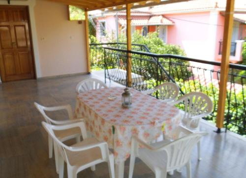 a table and white chairs on a balcony with a table and chairsktop at Villa Xenos in Kalamaki