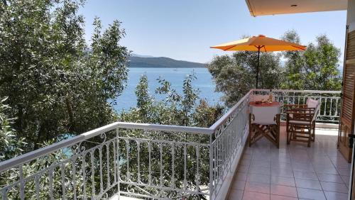 a balcony with a table and an umbrella at Tzeni Villa in Lygia