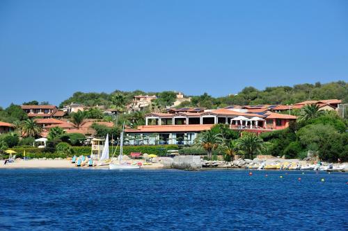 a resort on a beach with boats in the water at Hotel Club Saraceno - Bovis Hotels in Àrbatax