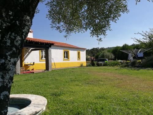 una casa amarilla y blanca en un patio en Casa das Amoras, en Santo António das Areias