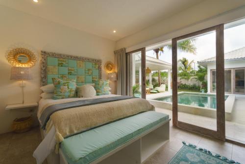 - une chambre avec un lit et une piscine dans l'établissement Sunyi Villas, à Kuta Lombok