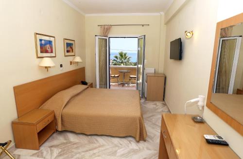 um quarto de hotel com uma cama e uma casa de banho em Katerina Hotel em Agia Marina