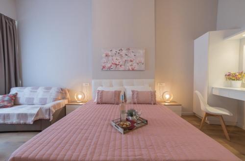 a bedroom with a pink bed with a tray on it at Saint George unique studio in Nafplio