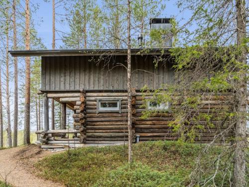 a log cabin cabin in the woods with trees at Holiday Home Tievatupa 1- isompi by Interhome in Ylläsjärvi