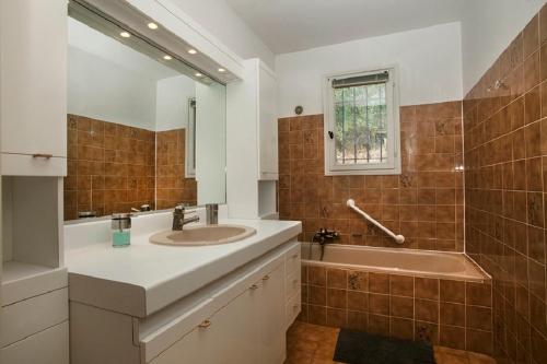 une salle de bain avec un lavabo et une baignoire dans l'établissement Villa provençale avec piscine-56, à La Garonnette-Plage
