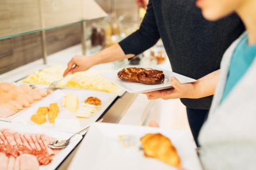 a person is preparing food at a buffet at harry's home hotel & apartments in Vienna
