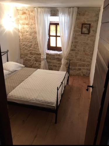 a bedroom with two beds and a window at Apartments Malic in Pridraga