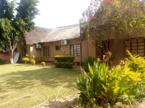 une maison avec un jardin en face dans l'établissement Ntshe River Lodge, à Francistown
