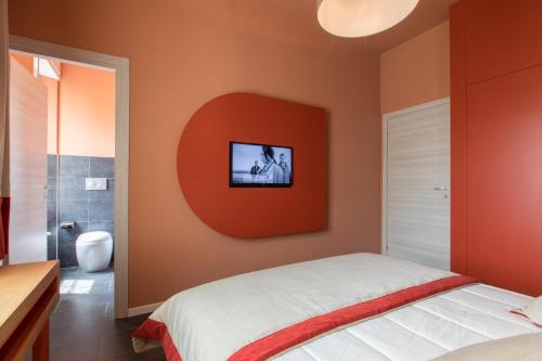 a bedroom with an orange wall with a tv on it at Le Texture Premium Rooms Duomo-Cordusio in Milan