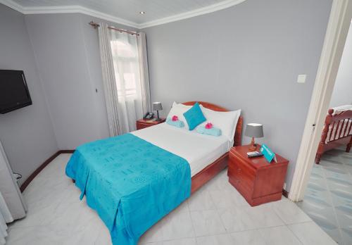 sypialnia z łóżkiem i telewizorem w obiekcie Gold Beach Resort w mieście Flic-en-Flac