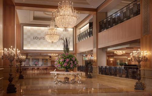 a lobby with a table with flowers and chandeliers at Grand Hi Lai Hotel in Kaohsiung