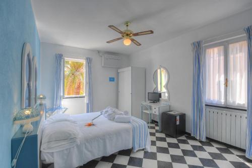 a bedroom with a bed and a ceiling fan at Hotel Arabesque in Varigotti