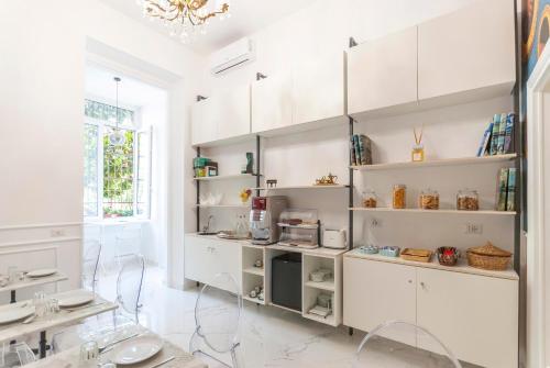 ローマにあるBea Suites Luxury Roomsの白い棚と窓のある白いキッチン