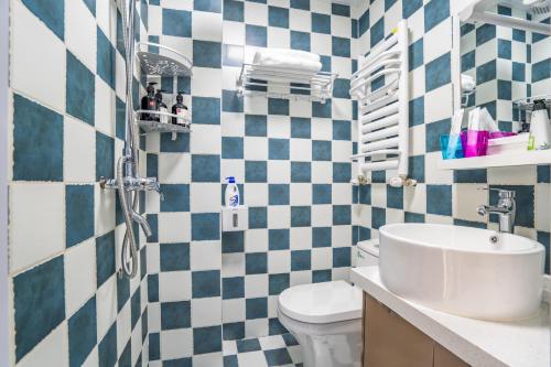 a bathroom with blue and white checkered tiles at Zhengzhou Huiji·Province Sport Centre· Locals Apartment 00161400 in Zhengzhou