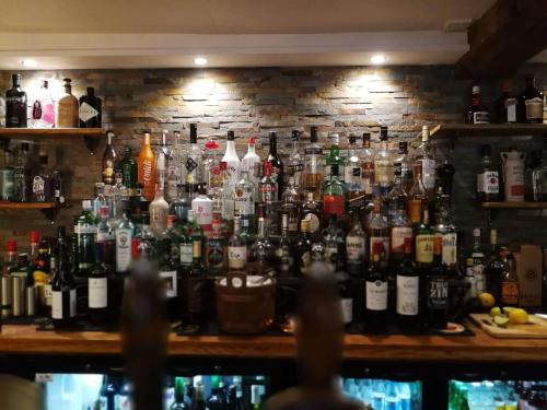 een bar met veel flessen aan de muur bij The Hood Arms in Kilve