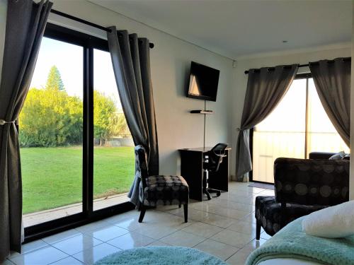 1 dormitorio con ventana grande con vistas al patio en Comfey Stay, en Ciudad del Cabo