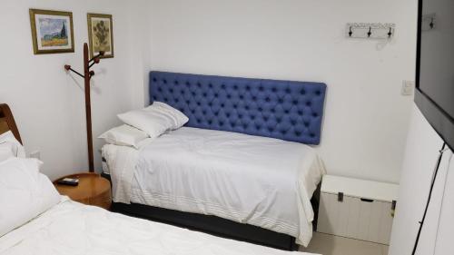 a bedroom with a blue headboard and two beds at Iberostate Praia do Forte Apartamento in Praia do Forte