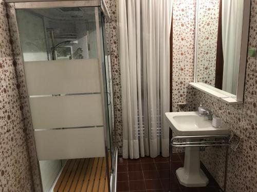 La petite salle de bains est pourvue d'un lavabo et d'une douche. dans l'établissement Villa Albina, à Rome