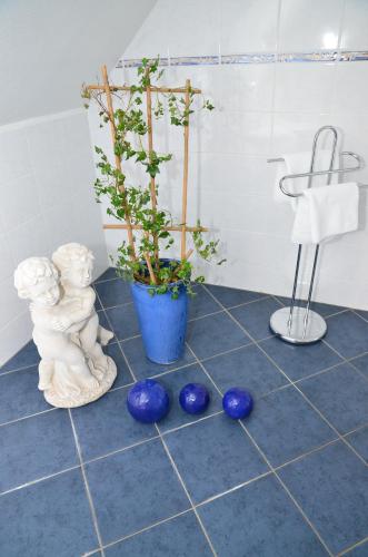 a bathroom with a potted plant and blue vases on the floor at Landhotel Gemeindeschänke in Wanfried
