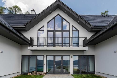 a house with a balcony and windows at Jaworowy Dom in Solina