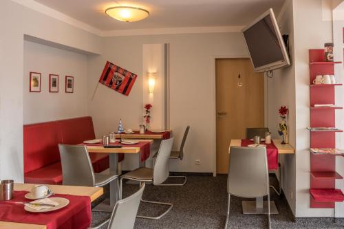 a restaurant with tables and chairs and a tv at Pension Torkel-Stube in Ingolstadt
