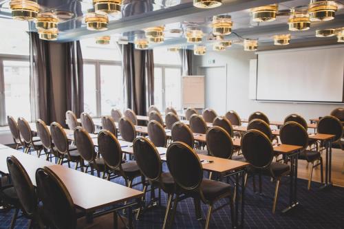 a classroom with desks and chairs in a room at Frøken Skjolds Hotel Lyngengården in Mosjøen