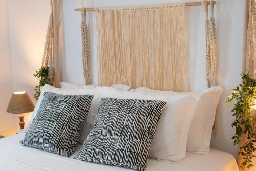 a bed with white pillows and a canopyinet at Chessboard decor House in Kamari