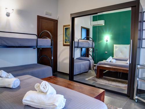 アーチ・サンタントニオにあるAntichi Ricordiの二段ベッド2台と鏡が備わる客室です。