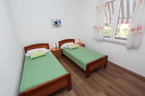 Un dormitorio con dos camas y una ventana. en Apartment Dina, en Rovinj