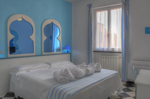 una camera da letto con un letto e asciugamani di Hotel Arabesque a Varigotti