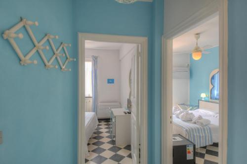 a bedroom with blue walls and a bed and a mirror at Hotel Arabesque in Varigotti