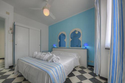 a bedroom with a bed with blue walls and a checkered floor at Hotel Arabesque in Varigotti