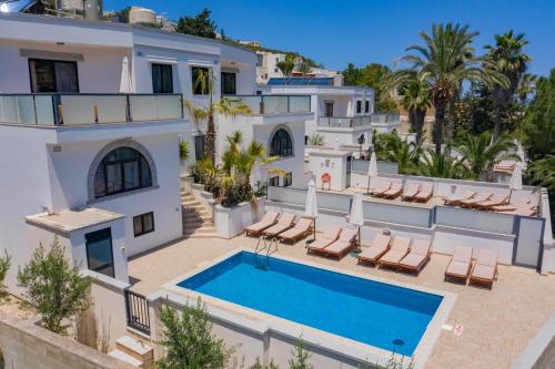 une grande maison blanche avec une piscine dans l'établissement Baldacchino Holiday Villas, à Mellieħa