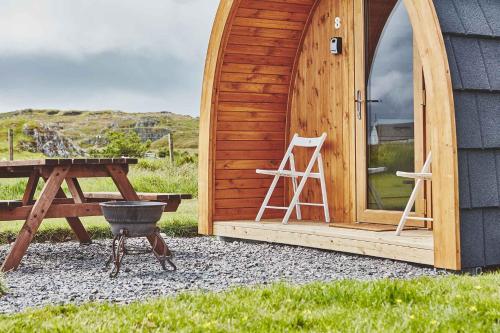 
a wooden bench in front of a wooden door at Iona Pods in Iona
