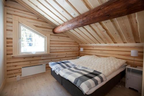 a bedroom with a bed in a wooden cabin at Timmervillan in Funäsdalen