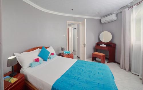 1 dormitorio con 1 cama grande y espejo en Gold Beach Resort, en Flic en Flac