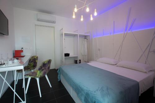 una camera con letto, scrivania e sedia di Sunrise Rooms a Grado