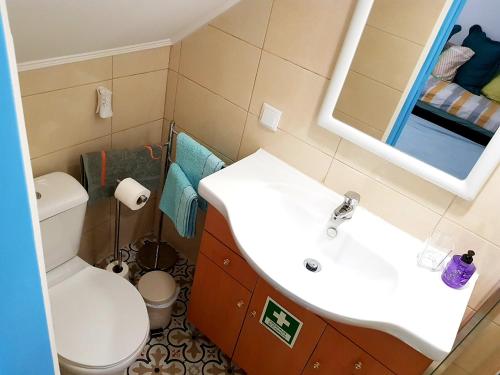 uma casa de banho com um WC, um lavatório e um espelho. em Dreaming Setubal em Setúbal
